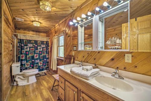 a bathroom with a sink and a toilet and a mirror at Spacious Cabin on Dale Hollow Lake with Hot Tub! in Albany