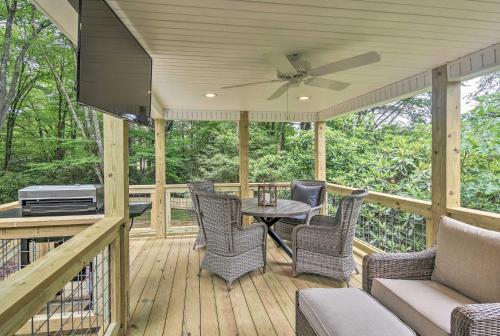 eine abgeschirmte Veranda mit einem Tisch und Stühlen sowie einem Deckenventilator in der Unterkunft Blowing Rock Home 1 Block to Downtown! in Blowing Rock