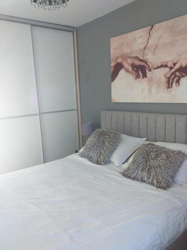 a bedroom with a white bed with a painting on the wall at Villa Helena in Dramalj