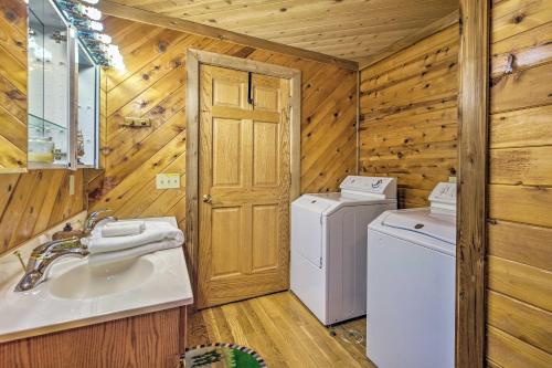 a bathroom with a sink and a washer and dryer at Spacious Cabin on Dale Hollow Lake with Hot Tub! in Albany