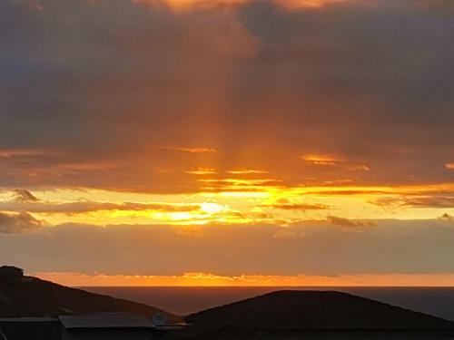 a sunset over the ocean with a cloudy sky at Seascape in De Kelders