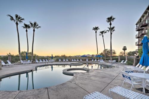 a swimming pool with chairs and palm trees at Walk to Golf and Beach Queens Bay Resort Condo in Lake Havasu City