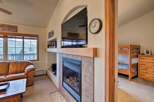 een woonkamer met een open haard en een televisie bij Condo with Mtn View, Less Than 1 Mi to Steamboat Resort! in Steamboat Springs