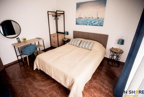 1 dormitorio con cama, escritorio y espejo en Explore Greece from Lovely City Centre Apartment, en Chalkida