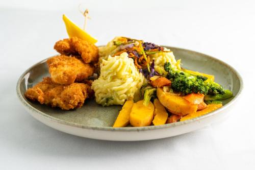 a plate of food with broccoli rice and vegetables at South Gap Hotel in Christ Church