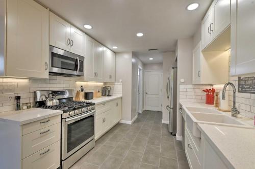 a kitchen with white cabinets and a stove top oven at Modern Flagstaff Home with BBQ Walk Downtown! in Flagstaff