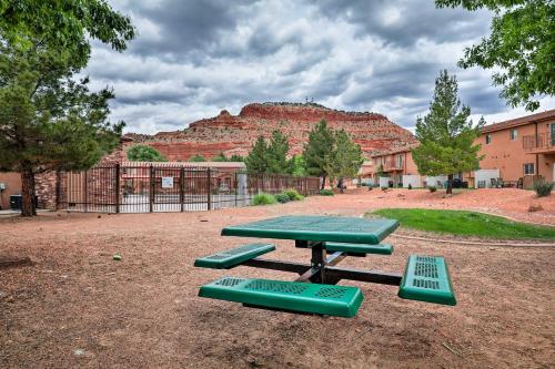 a picnic table with four green benches in a park at Kanab Condo with Pool and Patio, 30 Mi to Zion NP in Kanab