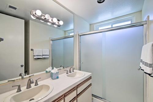 a bathroom with two sinks and a large mirror at Cathedral City Condo on Golf Course with Patio! in Cathedral City