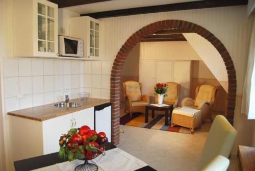 a kitchen with an archway with a table and chairs at Wohlfühlhotel Hörn van Diek Garni mit Schwimmbad in Bensersiel