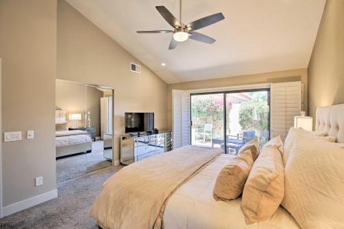 a bedroom with a large bed with a ceiling fan at Luxury Remodeled Palm Desert Resort Condo! in Palm Desert