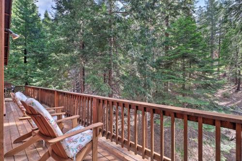 a rocking chair on a deck with a view of trees at Walk to Big Trees State Park Cabin with Deck! in Dorrington