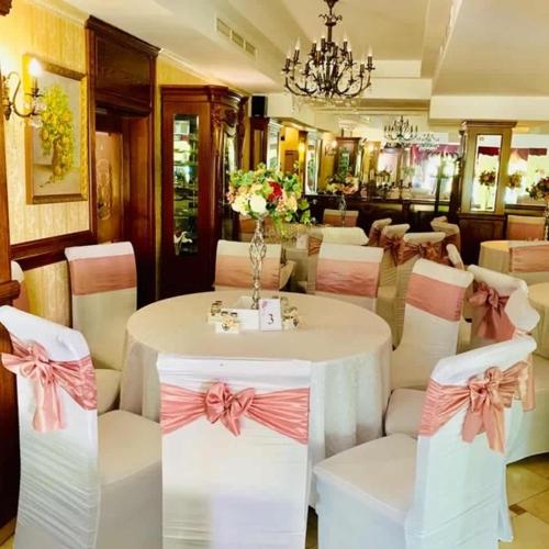 a dining room with a table and chairs with bows at Vila Royal in Bacău