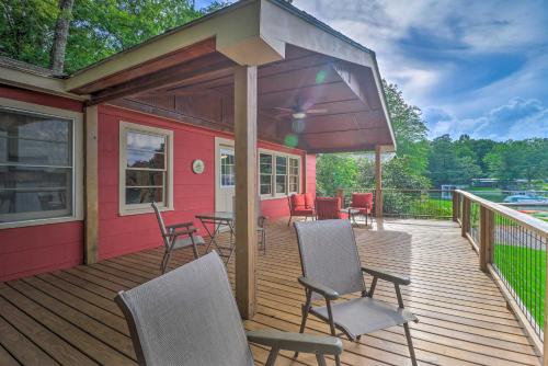 a covered deck with chairs and tables on a house at Waterfront Lake Martin Home with Grill and Beach! in Eclectic