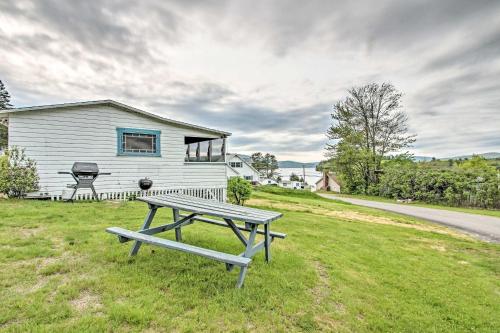 a picnic table in the grass in front of a house at Newfound Lake Studio BBQ, Fire Pit and Beach Access in Bristol