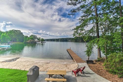 a dock on a lake with two picnic tables at Waterfront Lake Martin Home with Grill and Beach! in Eclectic