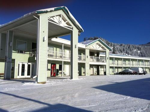 a large building with a parking lot in the snow at Ponderosa Motor Inn in Golden