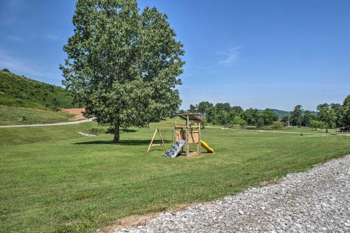 a playground in a field with a tree at Guntersville Lake Cabin with 3 Fishing Ponds! in Guntersville