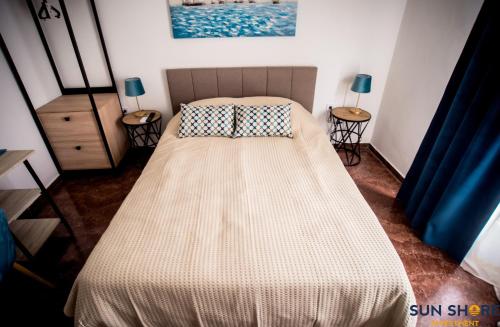 łóżko w sypialni z dwoma stołami i dwoma lampami w obiekcie Explore Greece from Lovely City Centre Apartment w Chalkidzie
