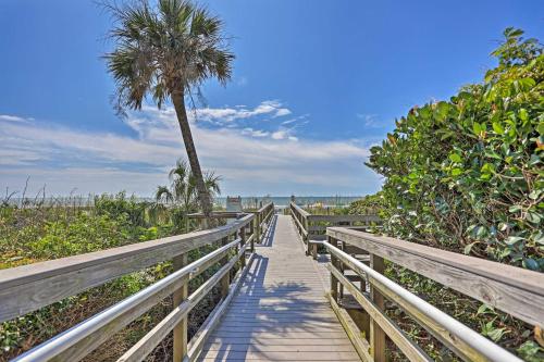 a wooden boardwalk to the beach with a palm tree at Community Pool Access Condo in Myrtle Beach in Myrtle Beach