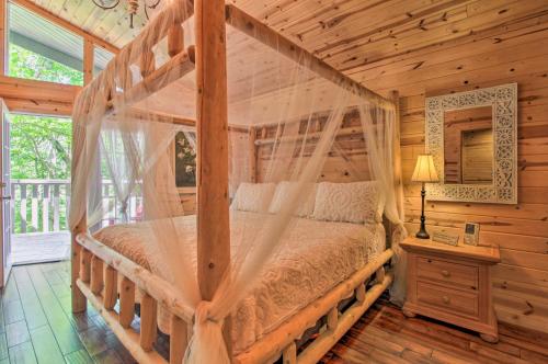 a bedroom with a canopy bed in a log cabin at Rustic Gatlinburg Chalet with Hot Tub 2 Mi to Town in Gatlinburg