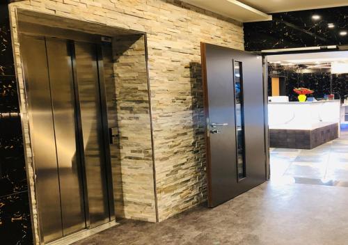 a lobby with two elevators and a brick wall at Elbgalerie Hotel in Hamburg