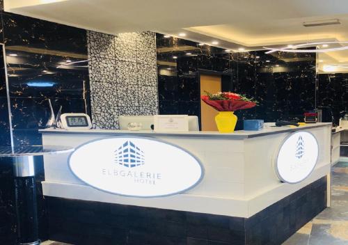un comptoir avec deux signaux blancs sur celui-ci; dans l'établissement Elbgalerie Hotel, à Hambourg