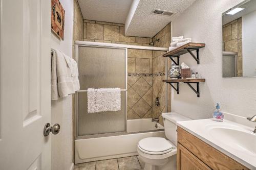 a bathroom with a shower and a toilet and a sink at Lake of the Ozarks Home with Game Room, BBQ and Dock! in Osage Beach