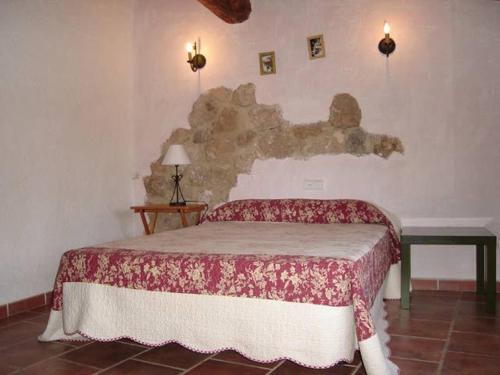 - une chambre dotée d'un lit avec une couverture rouge et blanche dans l'établissement Casa Rural Albayacín, à Letur