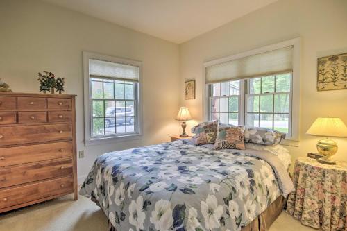 a bedroom with a bed with a dresser and two windows at Spacious Mercersburg Home at Whitetail Resort in Clear Spring