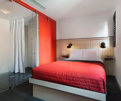a bedroom with a red bed and a shower at Pod 39 in New York