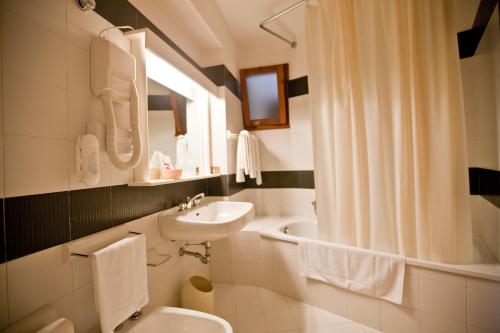 La salle de bains est pourvue d'un lavabo, de toilettes et d'une baignoire. dans l'établissement Hotel Moderno, à Erice