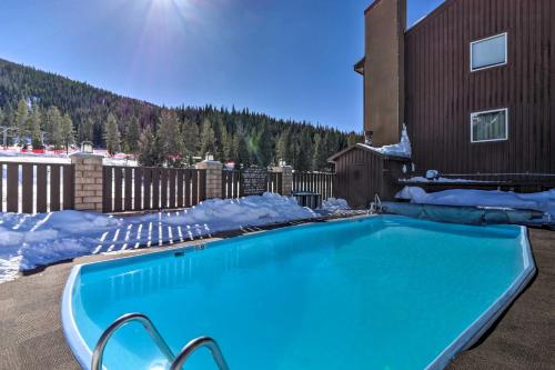 a swimming pool covered in snow next to a building at Walk to Copper Mountain Lifts Mtn-View Condo in Copper Mountain