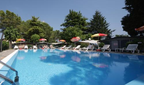 una gran piscina con sillas y sombrillas en Camping Garden Tourist, en Manerba del Garda