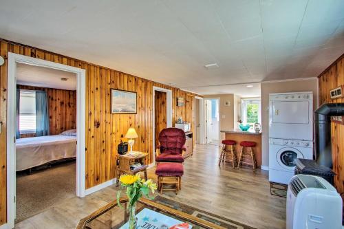 a bedroom with a bed and a living room with a chair at Cozy Hampton Cottage - Walk to Beaches and Marina! in Hampton