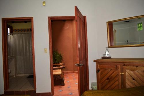 a bathroom with an open door and a mirror at La Gloria de Los Ángeles in Tzintzuntzán