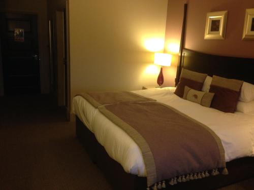 a hotel room with a bed and a lamp at Dumfries Arms Hotel in Cumnock