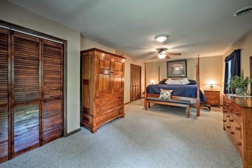 a bedroom with a bed and a wooden dresser at Waterfront Lake Barkley Home with Deck and Fire Pit! in Cadiz