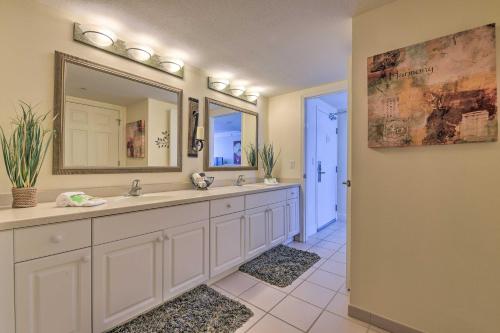 a bathroom with two sinks and a large mirror at Daytona Beachfront Condo with Ocean View in Daytona Beach