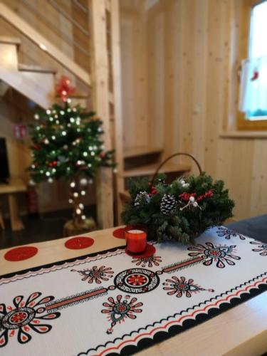 a cake with christmas decorations on a table with a christmas tree at HRYCÓWKA Domki z Widokiem in Grywałd