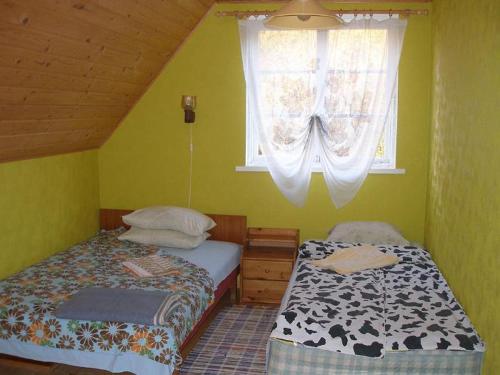 two beds in a small room with a window at Andrese Holiday Home in Muratsi
