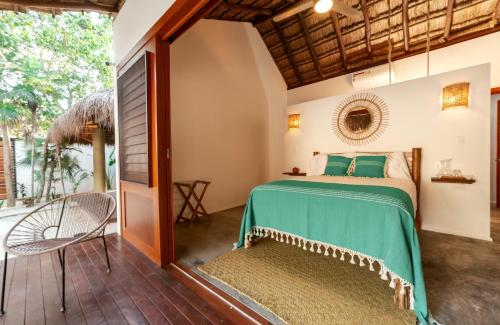 1 dormitorio con 1 cama y patio en Mimosa Tulum en Tulum