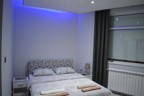 ein Schlafzimmer mit einem Bett mit zwei Handtüchern darauf in der Unterkunft MAGIC M Apartment in Mali Mokri Lug