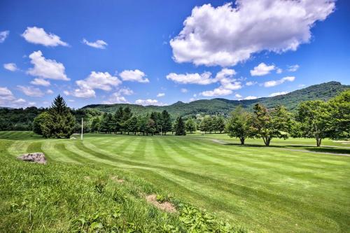a green field with trees and mountains in the background at Condo with Furnished Deck - Walk to Sugar Mountain! in Sugar Mountain