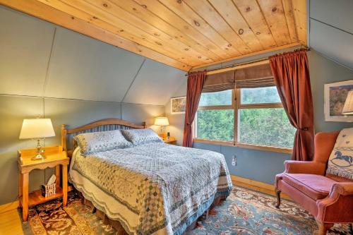 a bedroom with a bed and a chair and a window at Jacksonville Cabin with Wraparound Deck and Views in Jacksonville