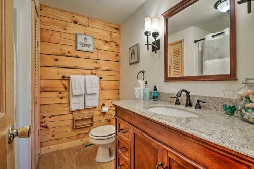 La salle de bains est pourvue de toilettes, d'un lavabo et d'un miroir. dans l'établissement Jacksonville Cabin with Wraparound Deck and Views, à Jacksonville