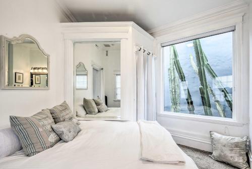 サンディエゴにあるSan Diego Home with Yard - 2 Blocks to the Bay!の大きな窓とベッドが備わる白い客室です。