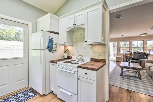 a kitchen with white appliances and a living room at Ephraim Home with Yard - Walk to Lake Michigan! in Ephraim