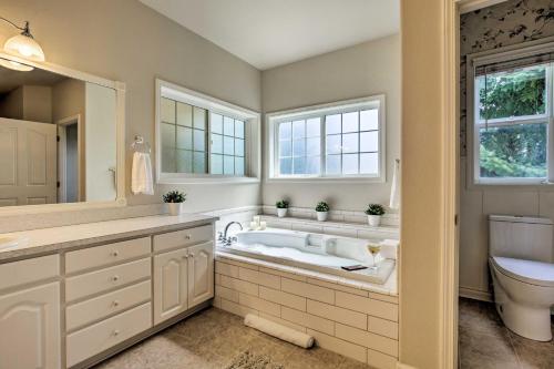 uma casa de banho com uma banheira, um lavatório e um WC. em McMinnville Wine Country Home with Hot Tub and Deck em McMinnville