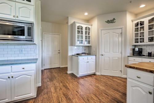 a large kitchen with white cabinets and a microwave at McMinnville Wine Country Home with Hot Tub and Deck in McMinnville