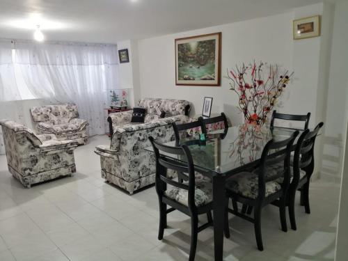 a living room with a glass table and chairs at Hostal Dante in San Gil